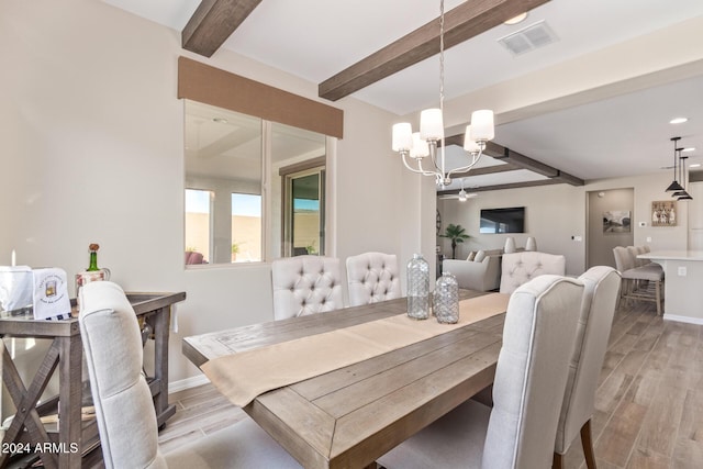 dining area with beamed ceiling, ceiling fan with notable chandelier, and light hardwood / wood-style floors