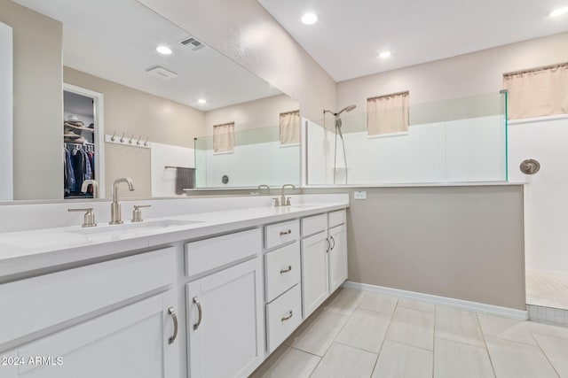 bathroom with tile patterned flooring, vanity, and walk in shower