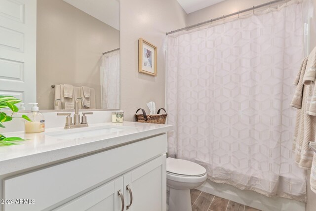 full bathroom with vanity, hardwood / wood-style floors, shower / bathtub combination with curtain, and toilet