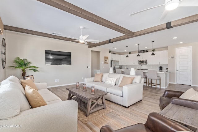 living room featuring beam ceiling, ceiling fan, and light hardwood / wood-style floors