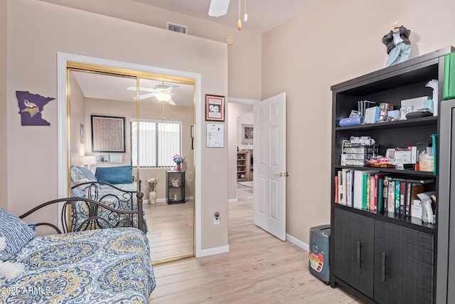 bedroom with light wood-style flooring, a closet, visible vents, and baseboards