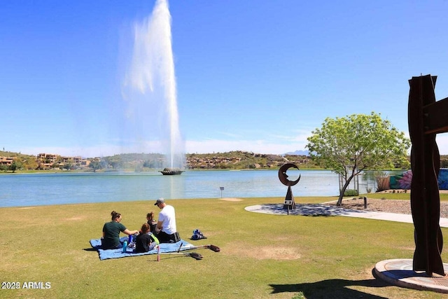 view of property's community with a water view and a yard