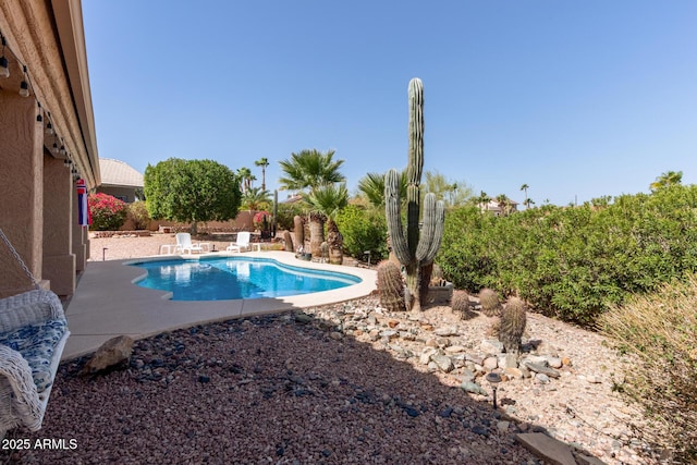 outdoor pool with a patio and a fenced backyard