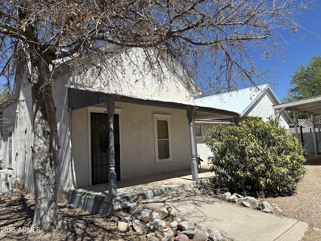 view of front of home featuring stucco siding and metal roof