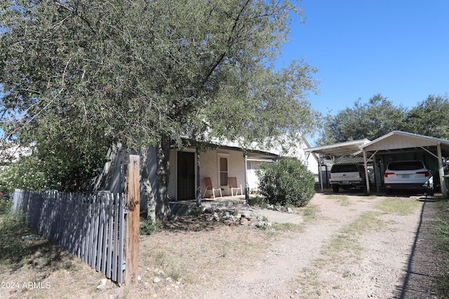 view of front of home featuring fence, driveway, and a carport