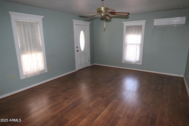 foyer featuring a ceiling fan, baseboards, a wall mounted AC, and wood finished floors