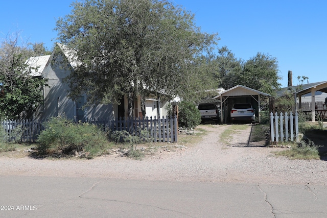 view of front of home featuring fence, a carport, and driveway
