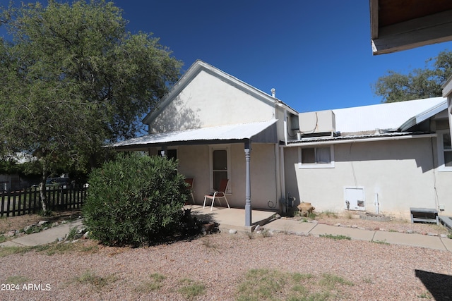 view of home's exterior with fence, metal roof, a patio area, and stucco siding