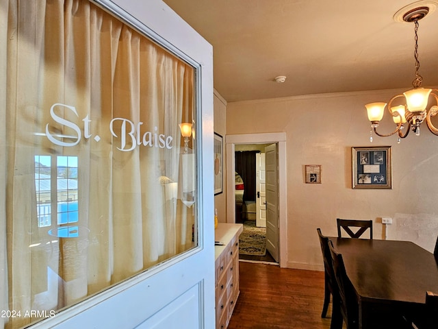 dining area with crown molding, a notable chandelier, and dark hardwood / wood-style flooring