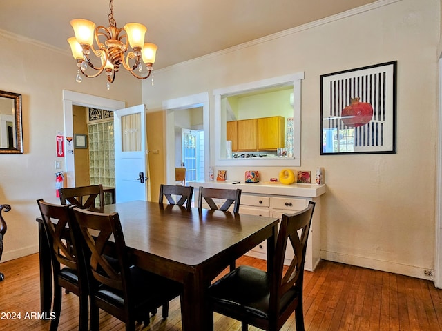 dining area featuring crown molding, hardwood / wood-style flooring, and a chandelier