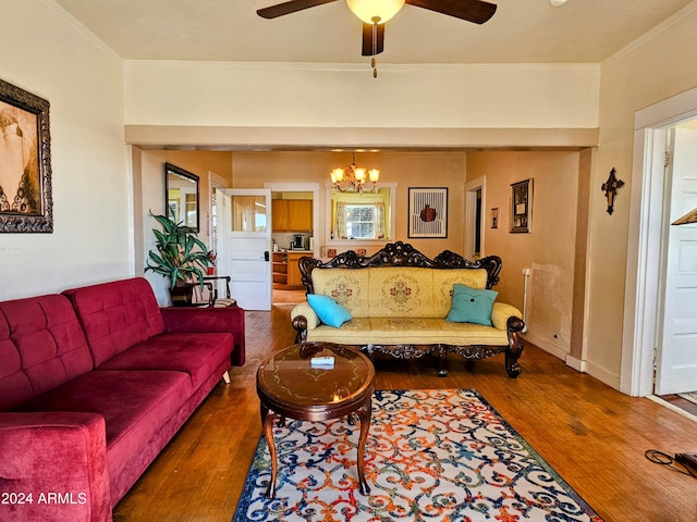 living room with ornamental molding, dark hardwood / wood-style floors, and ceiling fan with notable chandelier