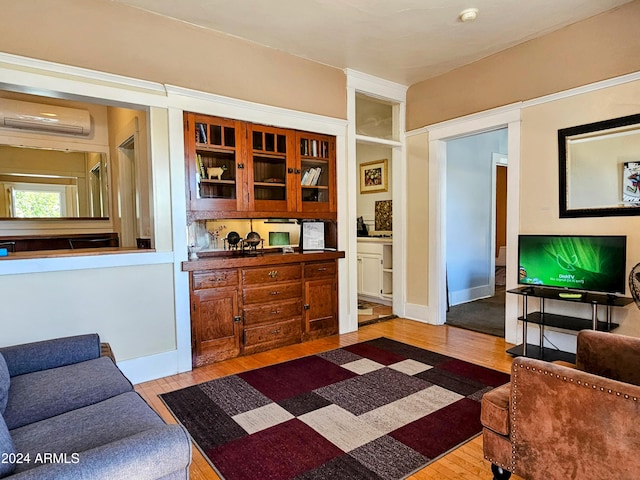 living room featuring light hardwood / wood-style flooring and a wall unit AC