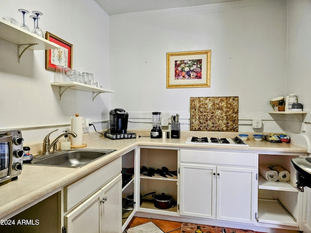 kitchen with white cabinetry, sink, and white gas cooktop