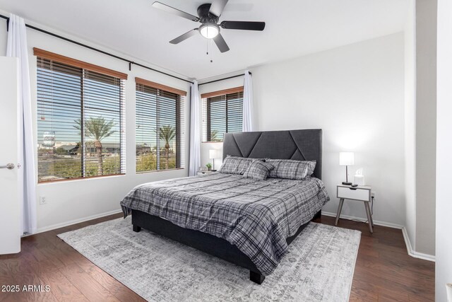 bedroom featuring a ceiling fan, dark wood-style flooring, and baseboards