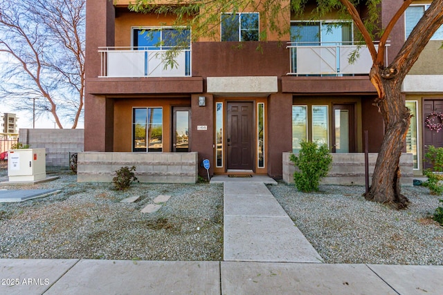 view of front of home with a balcony and stucco siding