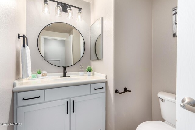 bathroom featuring toilet and vanity