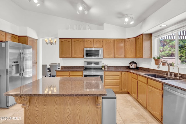 1831 W Armstrong Way, Chandler, AZ 85286 - kitchen with stainless steel appliances, lofted ceiling, light tile patterned flooring, a kitchen island, and dark stone countertops