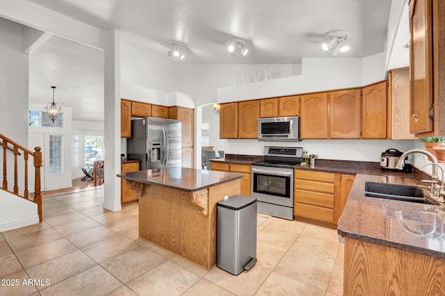 1831 W Armstrong Way, Chandler, AZ 85286 - kitchen featuring appliances with stainless steel finishes, lofted ceiling, dark stone counters, a chandelier, and a kitchen island