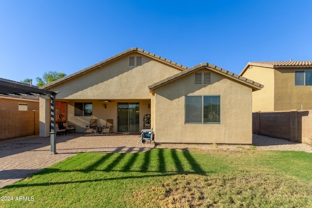 back of house with stucco siding, a ceiling fan, a patio, and a pergola