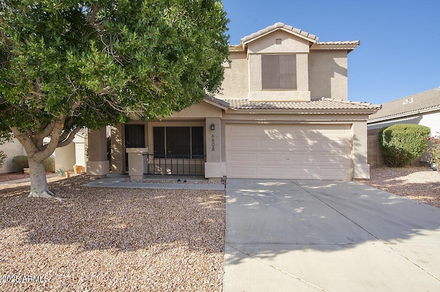 view of front of house featuring stucco siding, an attached garage, driveway, and a tile roof