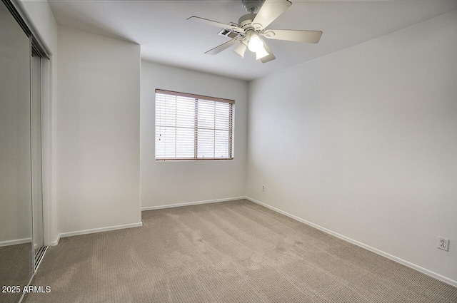 unfurnished bedroom featuring a ceiling fan, light colored carpet, a closet, and baseboards