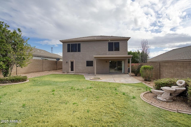 rear view of property featuring stucco siding, a lawn, a patio, a fenced backyard, and a tiled roof