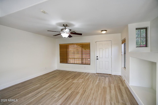 interior space featuring baseboards, light wood finished floors, and ceiling fan