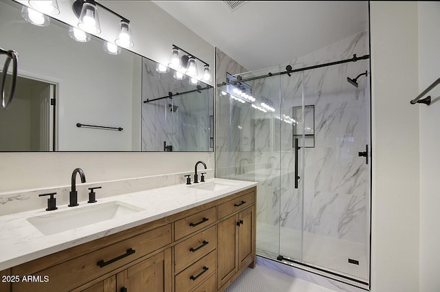 bathroom featuring double vanity, a marble finish shower, and a sink