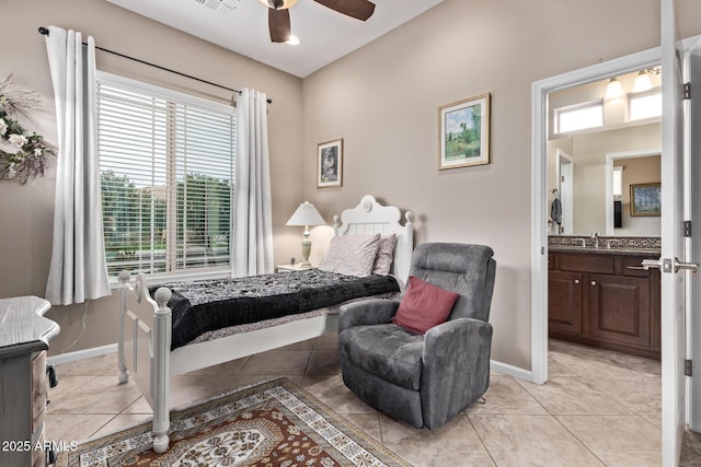 bedroom with ceiling fan, sink, light tile patterned floors, and ensuite bath