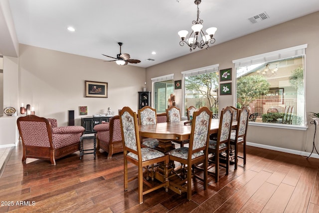 dining room with ceiling fan with notable chandelier and dark hardwood / wood-style floors