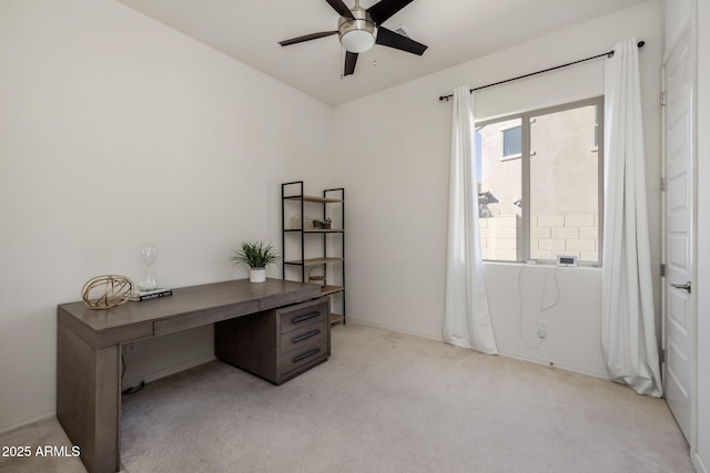 carpeted office space featuring ceiling fan