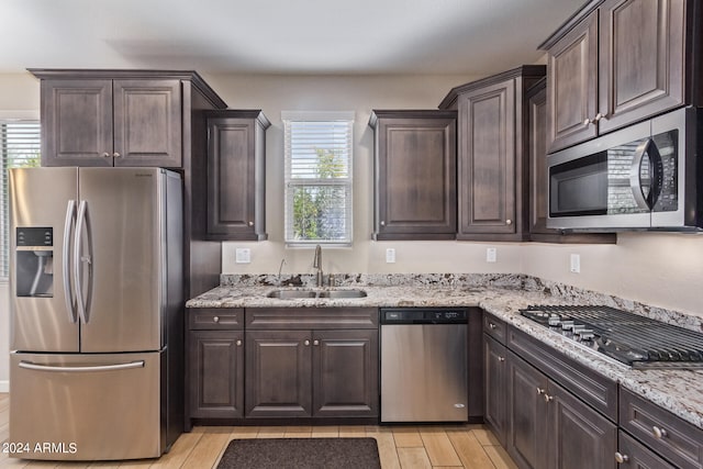 kitchen featuring a healthy amount of sunlight, appliances with stainless steel finishes, sink, and light wood-type flooring