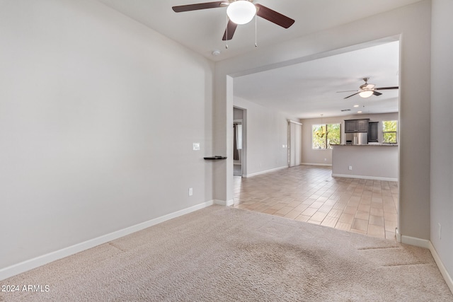 empty room featuring light carpet and ceiling fan