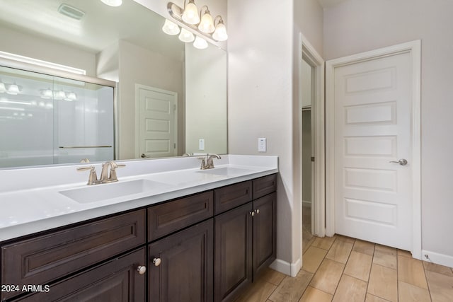 bathroom featuring vanity, wood-type flooring, and a shower with door