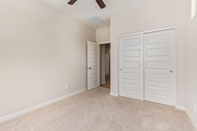 unfurnished bedroom with a closet, ceiling fan, and light carpet