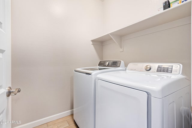 washroom with light hardwood / wood-style flooring and washer and dryer