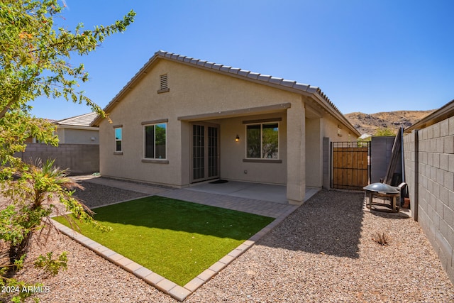 back of house with a patio and a yard