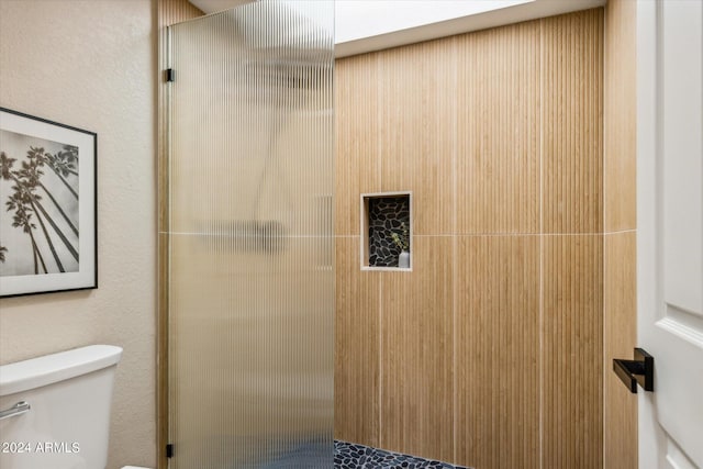 full bath featuring toilet and a tile shower