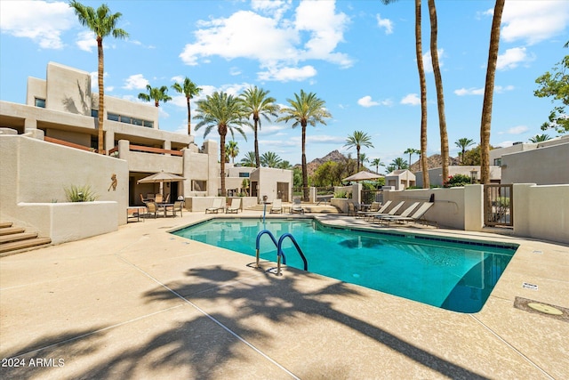 pool with a patio area and fence