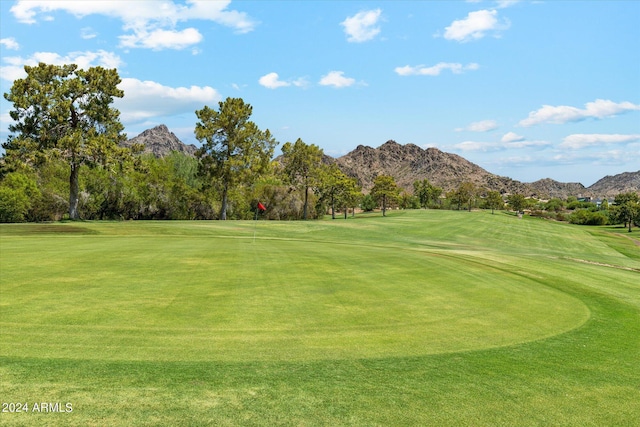 surrounding community featuring a mountain view, golf course view, and a lawn