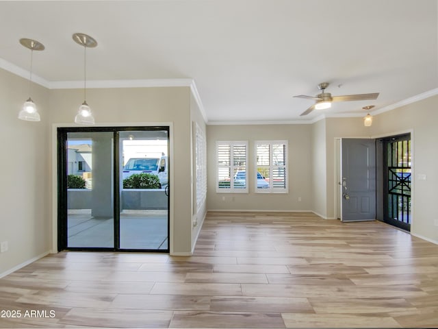 interior space with baseboards, light wood-style flooring, and crown molding