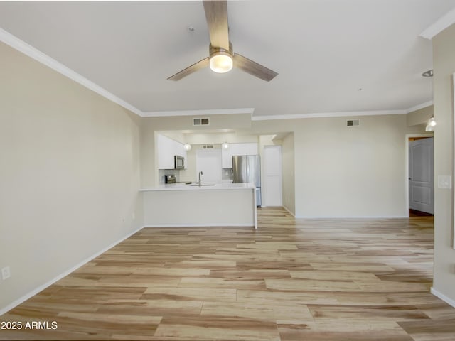 unfurnished living room featuring visible vents, ceiling fan, and light wood finished floors