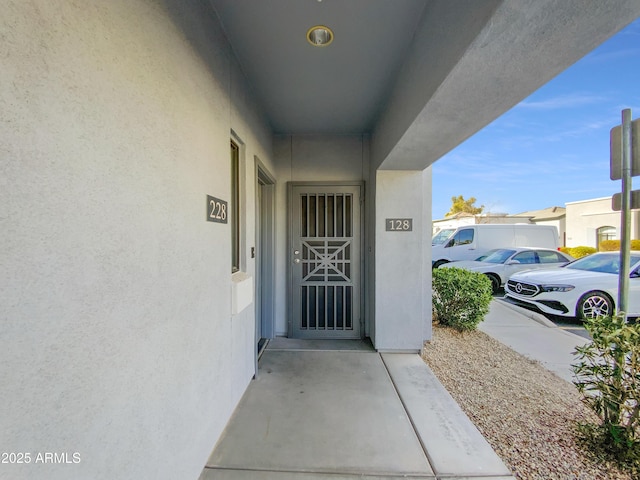 doorway to property featuring stucco siding