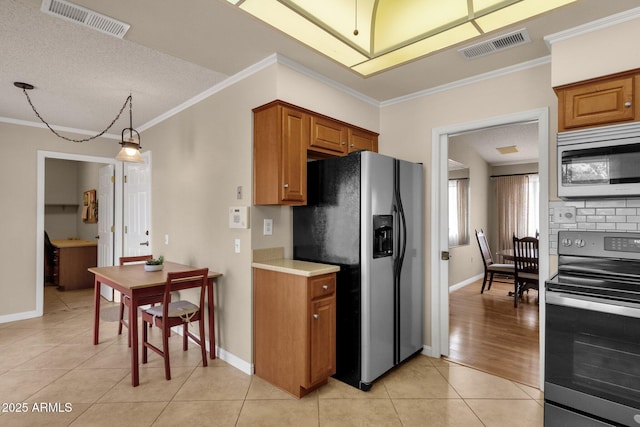 kitchen featuring light tile patterned floors, visible vents, appliances with stainless steel finishes, and ornamental molding