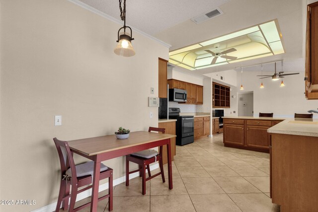 dining area featuring visible vents, ornamental molding, light tile patterned flooring, a raised ceiling, and ceiling fan