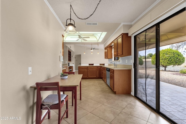 kitchen with visible vents, ornamental molding, ceiling fan, light countertops, and stainless steel dishwasher