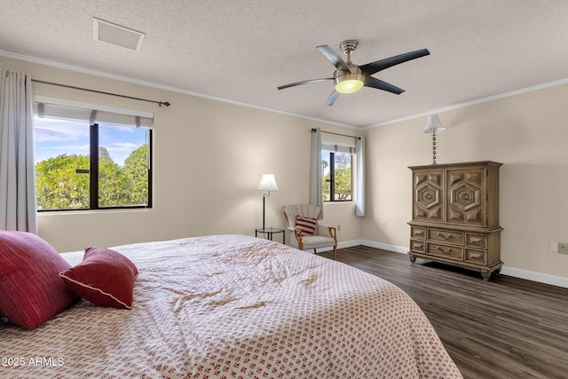 bedroom featuring dark wood finished floors, visible vents, a textured ceiling, and ornamental molding