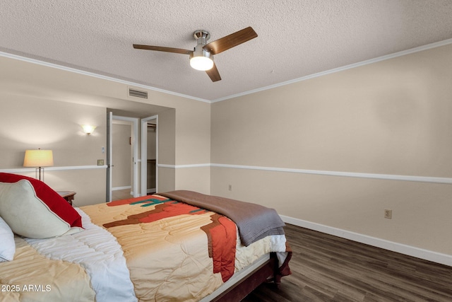 bedroom with visible vents, ornamental molding, a textured ceiling, wood finished floors, and baseboards