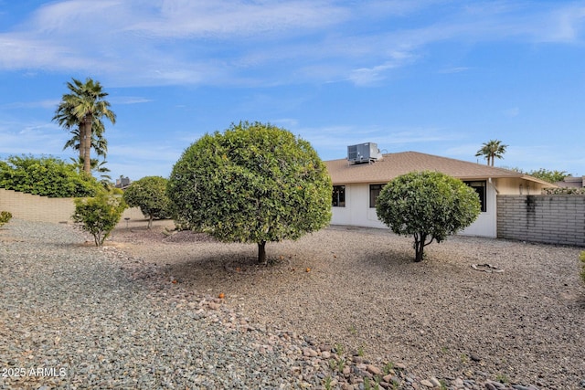 exterior space with central AC and fence