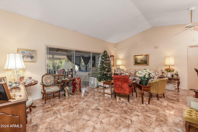 living room with a textured ceiling, vaulted ceiling, and ceiling fan